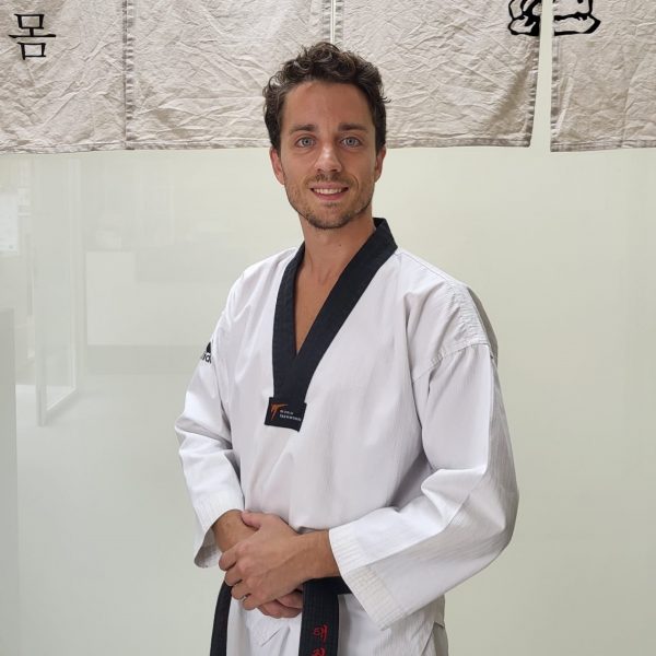 maestro Alex Marín sonriendo con un traje de Taekwondo